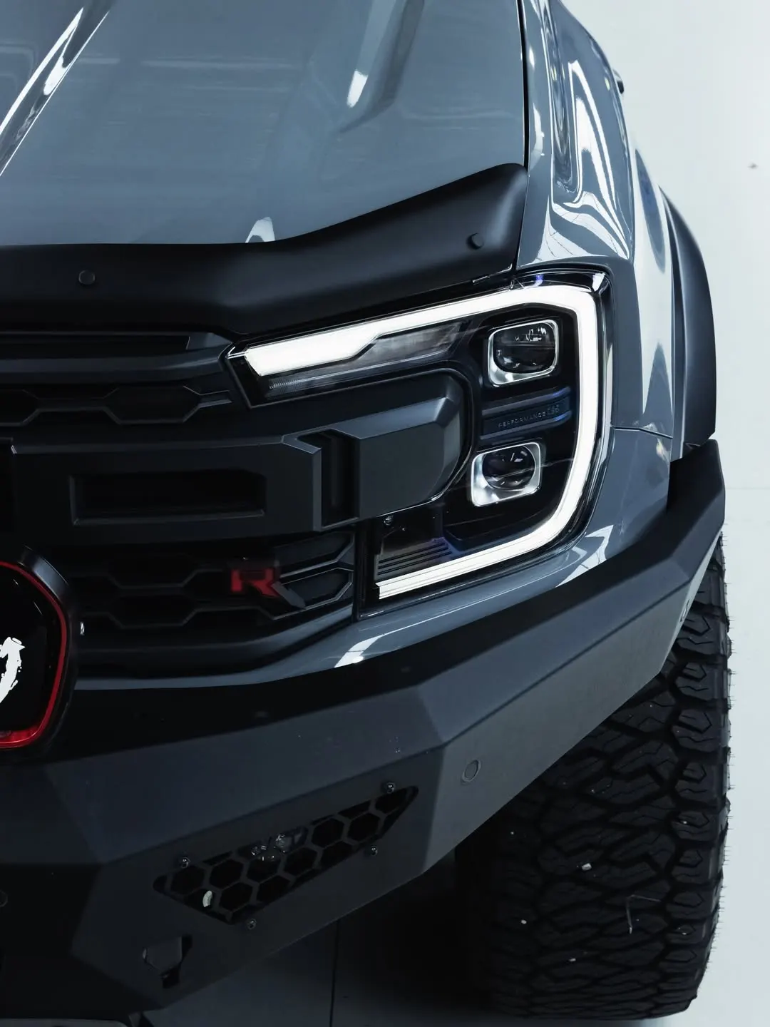 Headlight and grille of the Ford Raptor under clear film