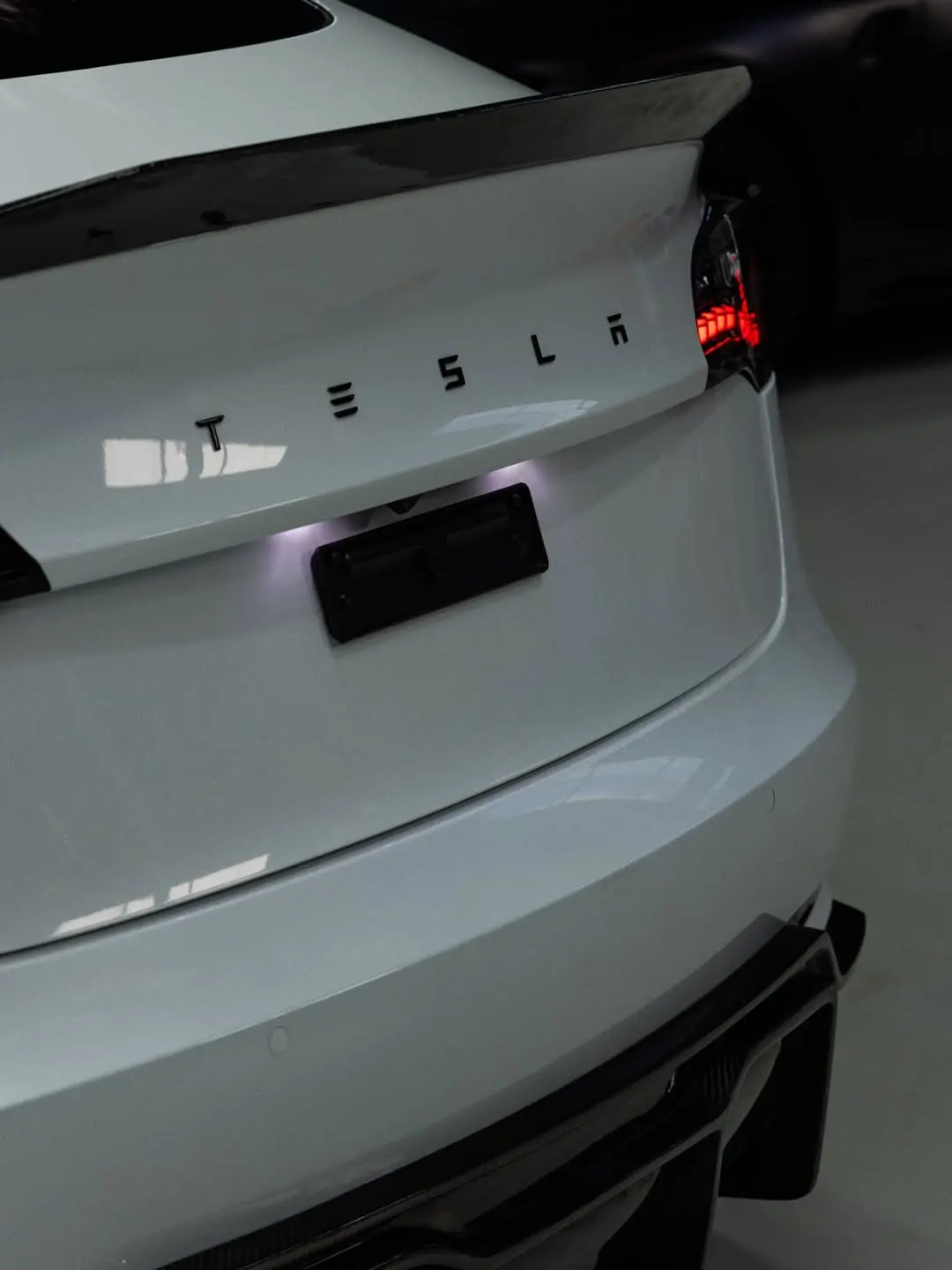 Tesla Model 3, the rear badge and spoiler.