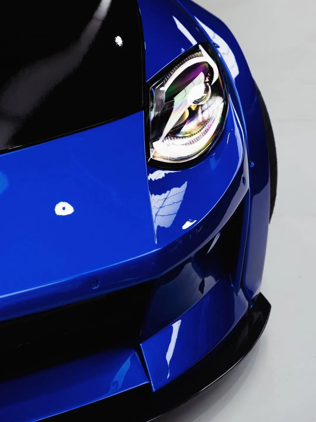 Gloss black bonnet meeting the blue front guard of the Nissan Z