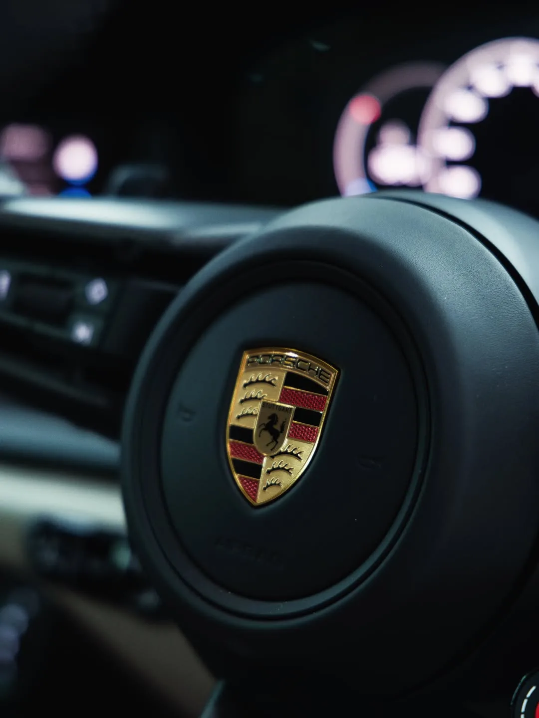 Porsche steering wheel crest photographed inside a freshly detailed cabin