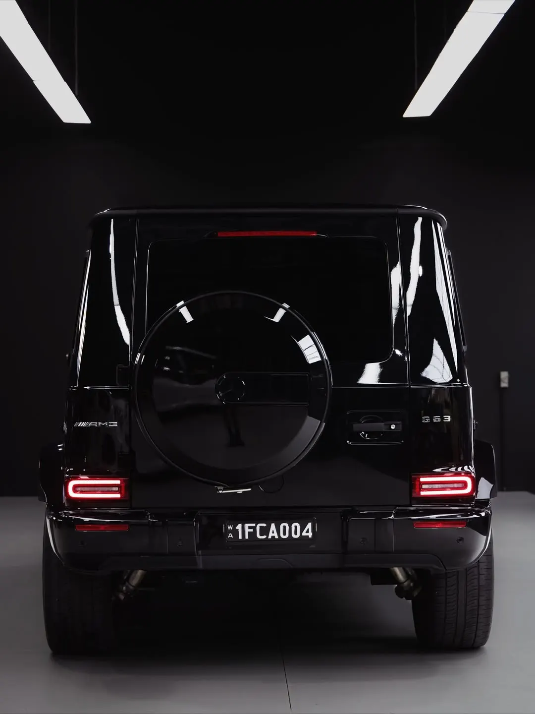 Gloss black Mercedes-AMG G63 presented under studio lighting