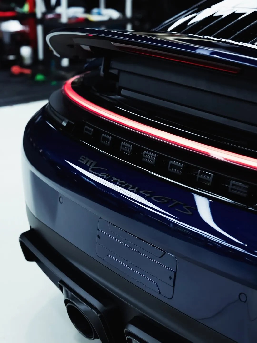 Close detail of corrected dark blue paintwork on a Porsche 911 Carrera 4 GTS